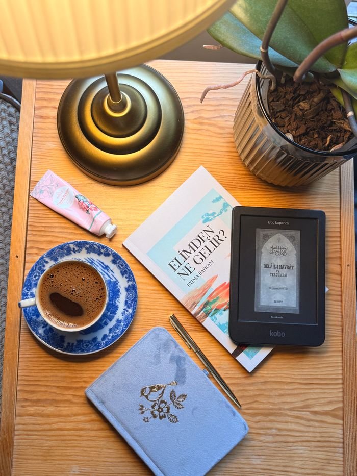 Warm tabletop scene featuring a coffee cup, books, and a lamp, perfect for a cozy reading corner.