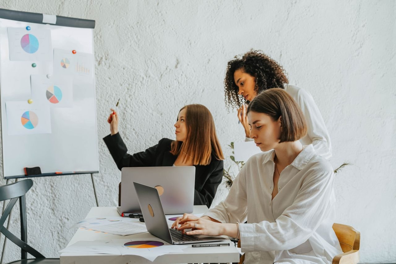 Mastering the First Impression: Your intriguing post title goes here Women working together on a business project with laptops and charts. Collaborative and diverse environment.